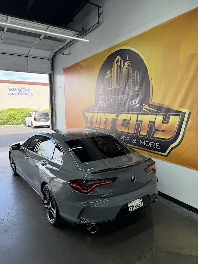 Rear view of a gray sports coupe in the Tint City workshop